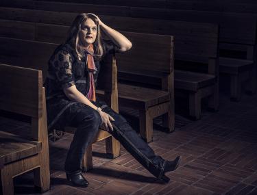 Elise istuu kirkossa tunnelmallisessa valossa